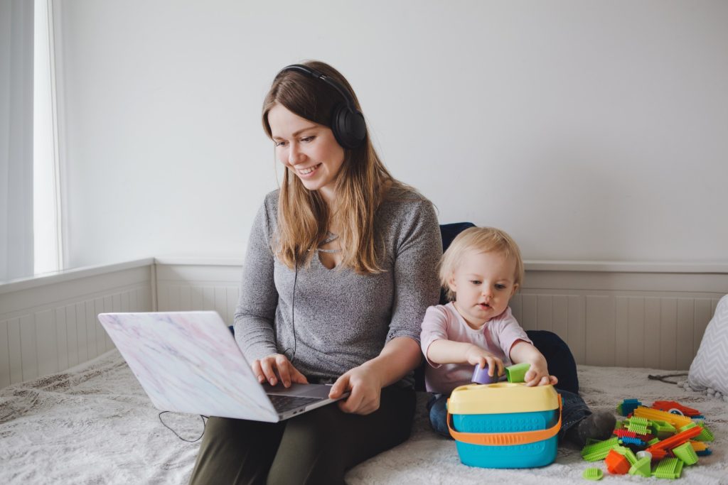 mother working from home while taking care of her child